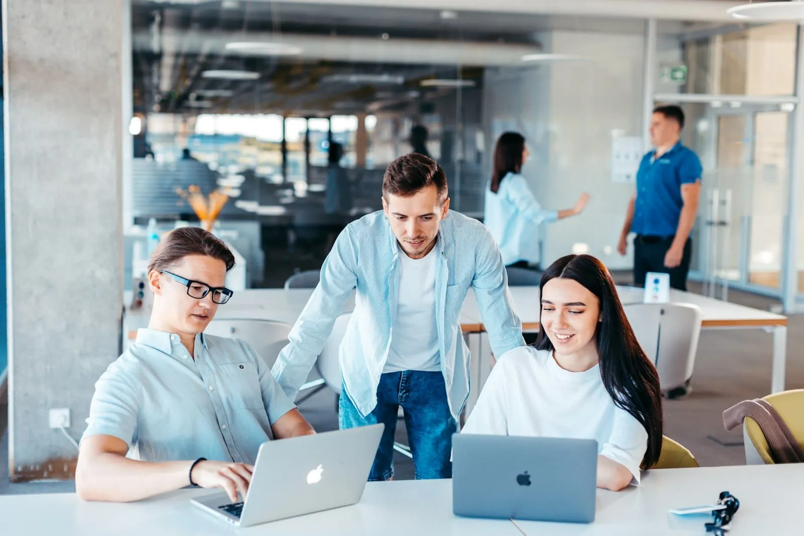 Profesionales de TI trabajan juntos con portátiles